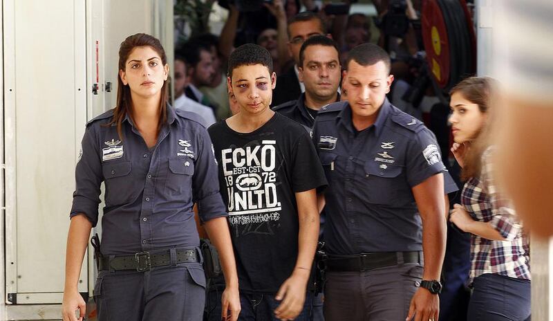 Tariq Abu Khdeir, centre, a 15-year-old American of Palestinian descent and a cousin of Mohammed Abu Khdeir, the youth whom Palestinians believe was murdered in revenge attacks over the deaths of three Israeli teens, is escorted by Israeli prison guards as he appears before a magistrate’s court in Jerusalem on July 6, 2014. The US has urged Israel to investigate allegations that Tariq was badly beaten by Israeli riot police. Ronen Zvulun / Reuters
