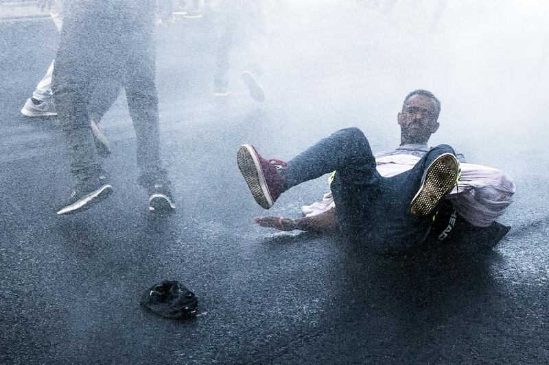 Italian police use water cannons to disperse about a hundred migrants protesting at Indipendenza square after being removed from an occupied building in Rome. Angeolo Carconi / EPA