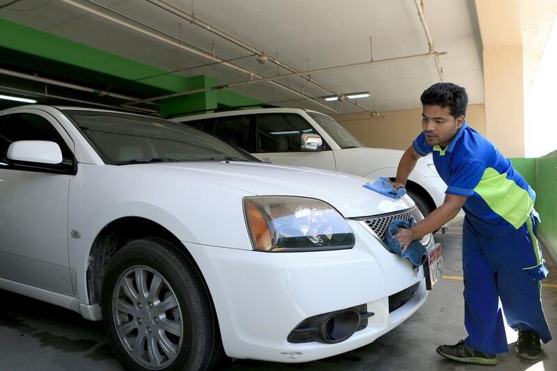 Washer Mithun Mondol puts a shine on a customer’s car at his workplace in the Al Wahda Mall car park. Ravindranath K / The National