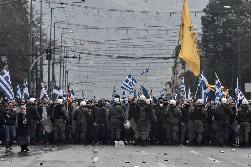 TOPSHOT - Protesters are blocked by riot police in Athens on January 20, 2019 during a demonstration against the agreement with Skopje to rename neighbouring country Macedonia as the Republic of North Macedonia. The proposal faces resistance in Greece because of what critics see as the implied claims to Greek land and cultural heritage. For most Greeks, Macedonia is the name of their history-rich northern province made famous by Alexander the Great's conquests. / AFP / Louisa GOULIAMAKI
