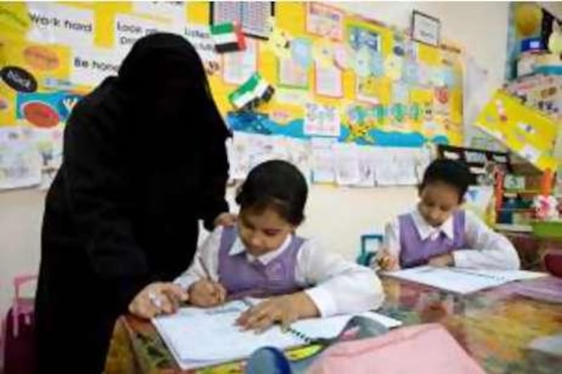 United Arab Emirates - Abu Dhabi - April 10 - 2008 -  Teacher Badrya Eissa asist a 3rd grade student at Khadeeja Al - Kubrah Primary School. ( Jaime Puebla - The National ) *** Local Caption *** JP102 - SCHOOL.jpg