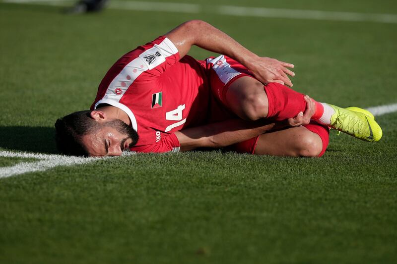 Palestine's Abdallah Jaber holds his leg as he lays on the floor. AP Photo