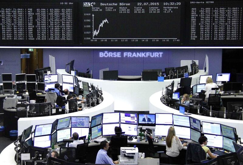 Traders are pictured at their desks in front of the DAX board at the Frankfurt stock exchange on July 22, 2015. Reuters