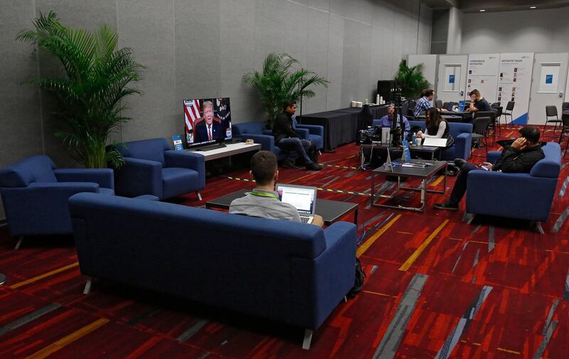 People sit on the couches inside the media room watch Donald Trump address the nation on a TV at the International Consumer Electronics Show in Las Vegas, Nevada. EPA