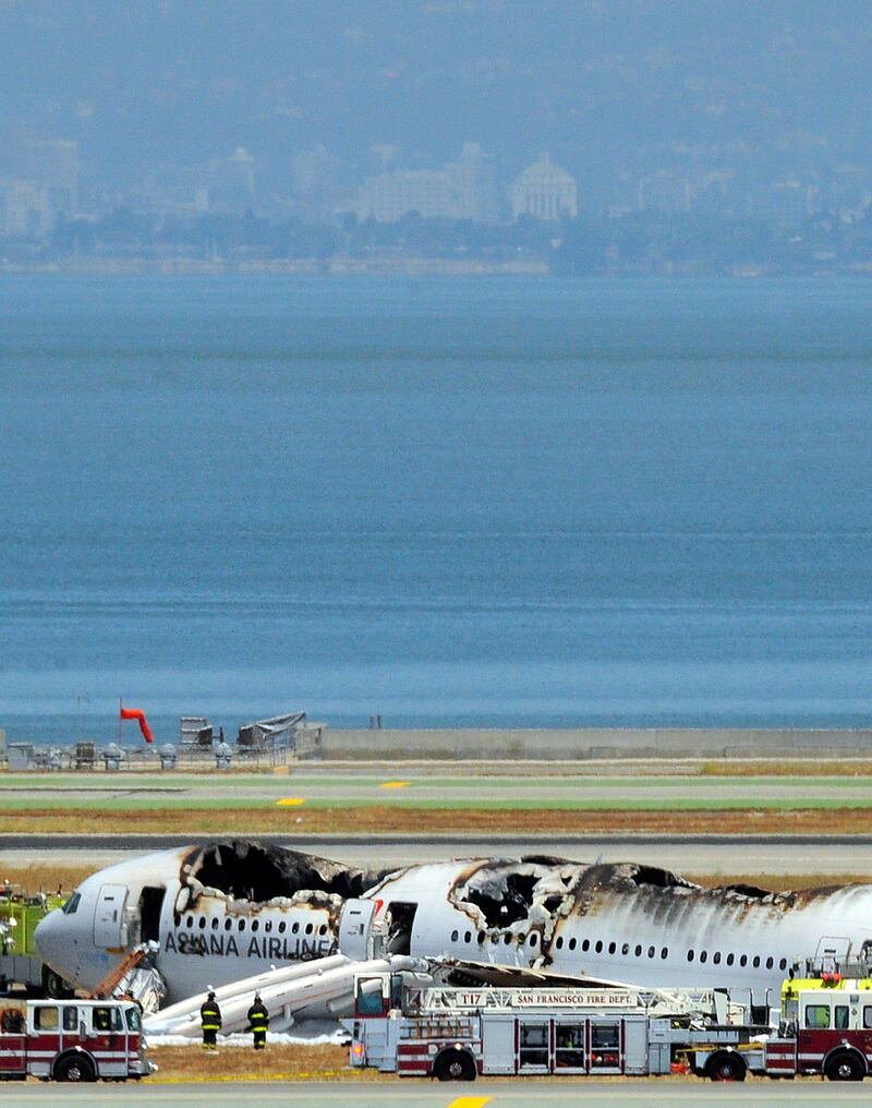 TOPSHOTS
An Asiana Airlines Boeing 777 is seen on the runway at San Francisco International Airport after crash landing on July 6, 2013. There were no immediate reports of casualties and one apparent survivor tweeted a picture of passengers fleeing the plane. Video footage showed the jet, Flight 214 from Seoul, on its belly surrounded by firefighters.     TOPSHOTS/AFP PHOTO/JOSH EDELSON
 *** Local Caption ***  504873-01-08.jpg