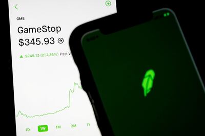 FILE PHOTO: Trading information for GameStop is displayed on the Robinhood App as another screen displays the Robinhood logo in this photo illustration January 29, 2021. REUTERS/Brendan McDermid/Illustration/File Photo