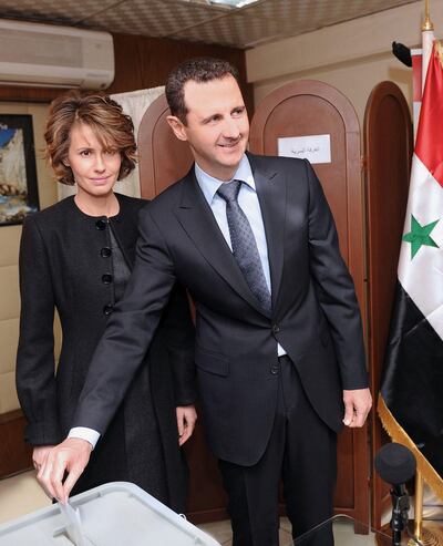 (FILES) This file handout picture released by the Syrian Arab News Agency (SANA) shows Syrian President Bashar al-Assad (R) and his wife Asma (L) voting on the constitution that could end five decades of single-party domination in Damascus. A decade of war may have ravaged his country, but Syria's President Bashar al-Assad has clung to power and looks determined to cement his position in presidential elections this year. / AFP / SANA / - / RESTRICTED TO EDITORIAL USE - MANDATORY CREDIT "AFP PHOTO / HO / SANA" - NO MARKETING NO ADVERTISING CAMPAIGNS - DISTRIBUTED AS A SERVICE TO CLIENTS
