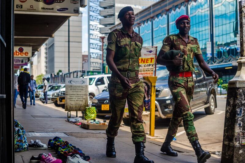 Zimbabwean soldiers walk by main streets in the Central Business District of Harare on November 20, 2017.
Zimbabwe is locked in one of its worst political crises since independence with President refusing to resign despite a military takeover, mass street protests and his dismissal from the ruling ZANU-PF party.  / AFP PHOTO / Jekesai NJIKIZANA