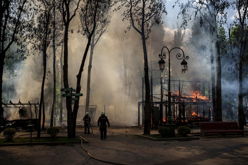 Firefighters work to extinguish flames after a Russian bombardment at a park in Kharkiv, Ukraine. AP Photo