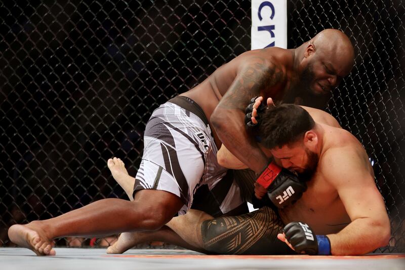 Derrick Lewis leans on Tai Tuivasa during their heavyweight fight at UFC 271. AFP