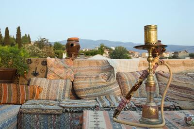 Turkey, Izmir Province, Selcuk, Ephesus, View from rooftop cafe with water pipe on table in foreground and traditional kilim textiles (Photo by: Eye Ubiquitous/UIG via Getty Images)