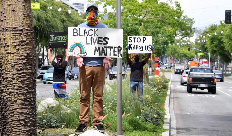 Activists hold placards in the middle of Santa Monica Boulevard in West Hollywood, California over the death of George Floyd.  AFP