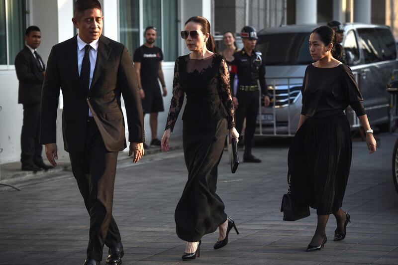 Nualphan Lamsam, centre, president and chief executive officer of Muang Thai Insurance and manager of Thailand women's national football team arrives at the temple. AFP