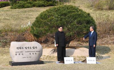 North Korea's leader Kim Jong Un (L) and South Korea's President Moon Jae-in (R) participate in a tree-planting ceremony next to the Military Demarcation Line that forms the border between the two Koreas at the truce village of Panmunjom on April 27, 2018.
North Korean leader Kim Jong Un and the South's President Moon Jae-in sat down to a historic summit on April 27 after shaking hands over the Military Demarcation Line that divides their countries in a gesture laden with symbolism. / AFP PHOTO / Korea Summit Press Pool / Korea Summit Press Pool