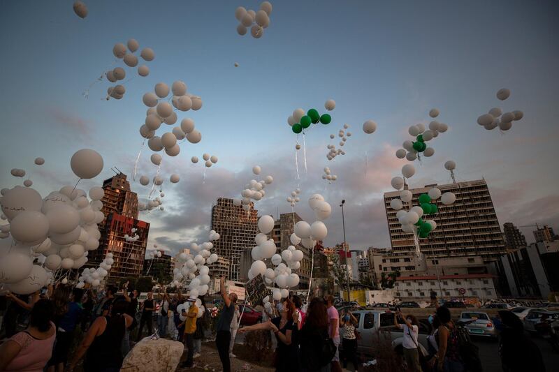 People release scores of white balloons bearing the names of victims killed in the Aug. 4 blast, at about 6:07 p.m., when the deadly explosion occurred, to mark the two-month anniversary, next to the seaport of Beirut, Lebanon, Sunday, Oct. 4, 2020. (AP Photo/Hassan Ammar)