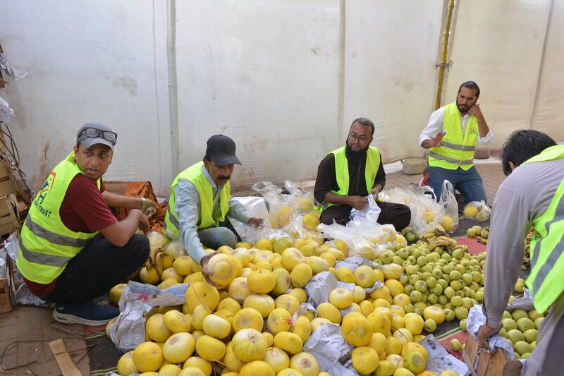 Mustafa Trust volunteers pack fruit at the stall 