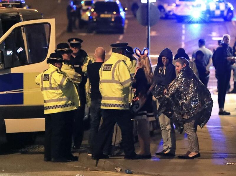 Police comfort young fans outside Manchester Arena. Most of those attending the Ariana Grande concert were young teenagers. PA via AP