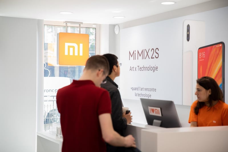 Customers wait to pay for their purchases at a service counter inside a Xiaomi Corp. store in Paris, France, on Friday, May 25, 2018. Chinese smartphone maker Xiaomi opened it's first store in Paris and plans for more shops in France, Spain and Italy, testing the appetite of consumers in developed markets as its executives consider a U.S. expansion. Photographer: Christophe Morin/Bloomberg