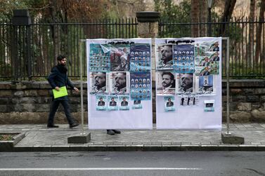 A man walks near parliamentary election campaign posters in Tehran, Iran. Reuters