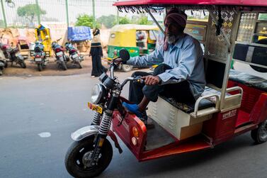 An electric auto-rickshaw driver drives along a road looking for passengers in the old quarters of New Delhi . The State Bank of India is forecasting GDP growth wil slow to 5 per cent this year, before recovering to 6.2 per cent next year. AFP