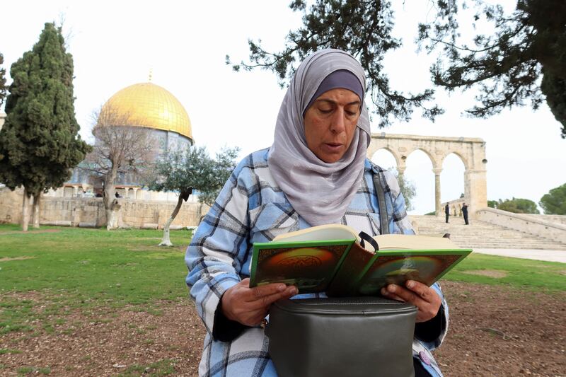 A Palestinian woman reads the Quran during the first day of Ramadan, at Al Aqsa Mosque compound in Jerusalem. Reuters