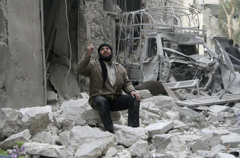 A man gestures while resting at a damaged site after what activists said was shelling by forces loyal to Syria's President Bashar Al Assad in Al Sukkari neighbourhood in Aleppo on February 2, 2014. Karam Al Halabi/Reuters