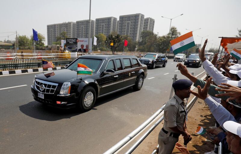 People wave as a motorcade transporting US President Donald Trump passes enroute to Sardar Patel Stadium in Ahmedabad, India. Reuters
