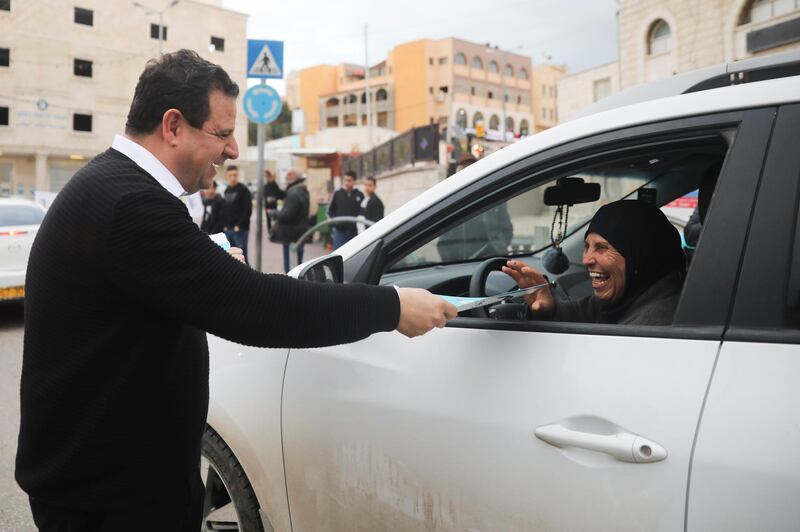 Ayman Odeh, Israeli Arab parliament member and leader of the Joint List alliance, hands a flier to a supporters during an election campaign event in then town of Yabeh, West Bank. AP