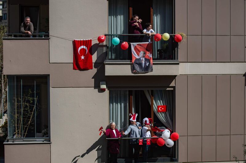 People celebrate with Turkish flags on their balconies to mark the National Sovereignty and Children's Day, in Istanbul, as the country is under lockdown to stop the spread of the Covid-19 pandemic. AFP