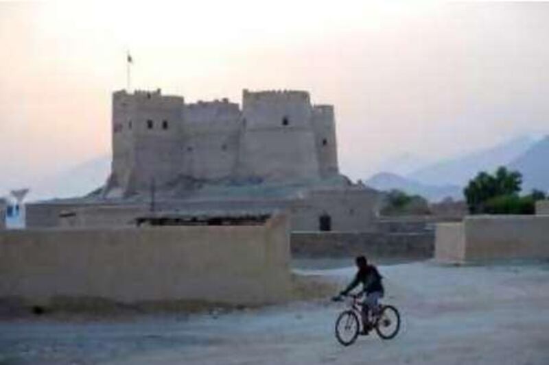 United Arab Emirates - Fujairah - Jun 24 - 2008: A man drives a bicycle in front of the  Fujairah Fort in Fujairah City. The Fort construction occured between 1500-1550. ( Jaime Puebla / The National ) Editors Note possible Oasis / 2008AD pictures. *** Local Caption ***  JP111 - FUJAIRAH FORT.jpgJP111 - FUJAIRAH FORT.jpg