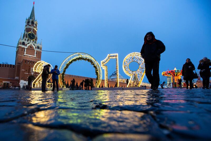 People walk past an installation for the new year on Red Square decorated for Christmas and New Year celebrations with the Spasskaya Tower in the background in Moscow, Russia. AP Photo