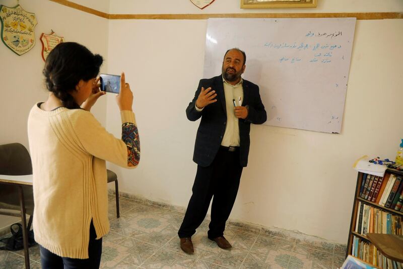 A Palestinian Arabic language teacher, Khader Soboh, is filmed by his daughter as he records an online class to his students during a home confinement order as a precaution, near Tubas in the Israeli-occupied West Bank. Reuters