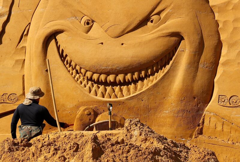 A sand carver works on a sculpture from 'Finding Nemo' during the Sand Sculpture Festival. Yves Herman / Reuters