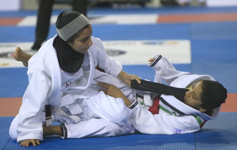 ABU DHABI - UNITED ARAB EMIRATES - 06NOV2015 - Hanna Ali (red belt) fights with Mouza Mohammed Khalifa in the Martyrs Championships for juniors Jiu Jitsu yesterday at IPIC Arena at Zayed Sports City in Abu Dhabi. Ravindranath K / The National (to go with Amit story for Sports)