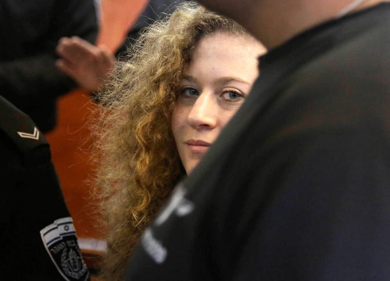 epa06618547 (FILE) - Palestinian teenager Ahed Tamimi (C) is escorted by Israeli military personnel as she appears at the Israeli Ofer military court  for a hearing on the extension of her detention, near the West Bank village of Betunia, 13 February 2018 (reissued 21 March 2018). According to reports, prescutors and lawyers for Tamimi on 21 March 2018 reached a deal that would have Tamimi serve a prison sentence of eight months. Tamimi, 17, was arrested on 19 December 2017 by the Israeli army after a video was posted of her slapping Israeli soldiers in the occupied West Bank as they remained impassive.  EPA/STRINGER *** Local Caption *** 54112423
