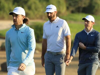 From left: Tommy Fleetwood of England, Dustin Johnson of the United States and Rory McIlroy of Northern Ireland walk on the 11th hole during round one of the Abu Dhabi HSBC Championship at Abu Dhabi Golf Club. Andrew Redington / Getty Images