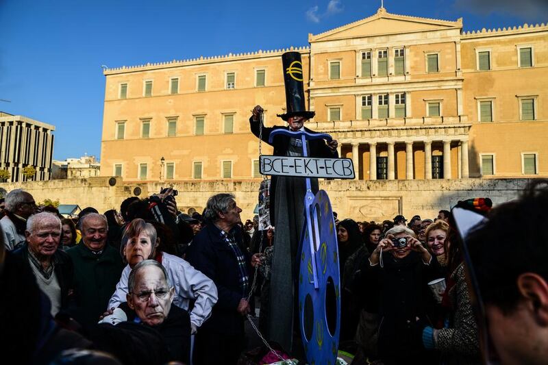 Protesters outside the Greek parliament in Athens, wearing masks of German chancellor Angela Merkel and finance minister Wolfgang Schäuble, front left, and, centre, a man rallies against the European troika. Getty Images