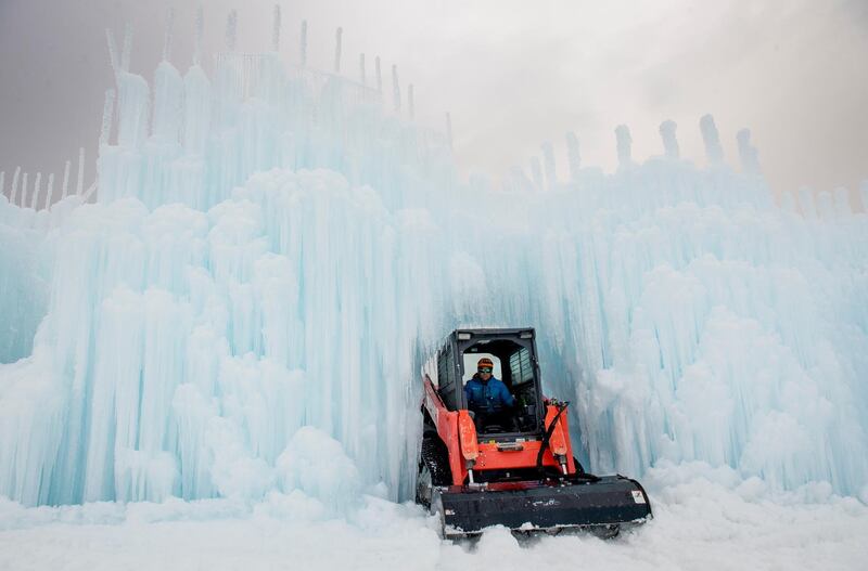 In this  photo, site manager Al Larsen softens snow and ice using a skidsteer to create a walking path while the Ice Castles are created at Homestead Resort in Midway, Utah. Crews worked since October to create the attraction ahead of the Friday opening date. AP