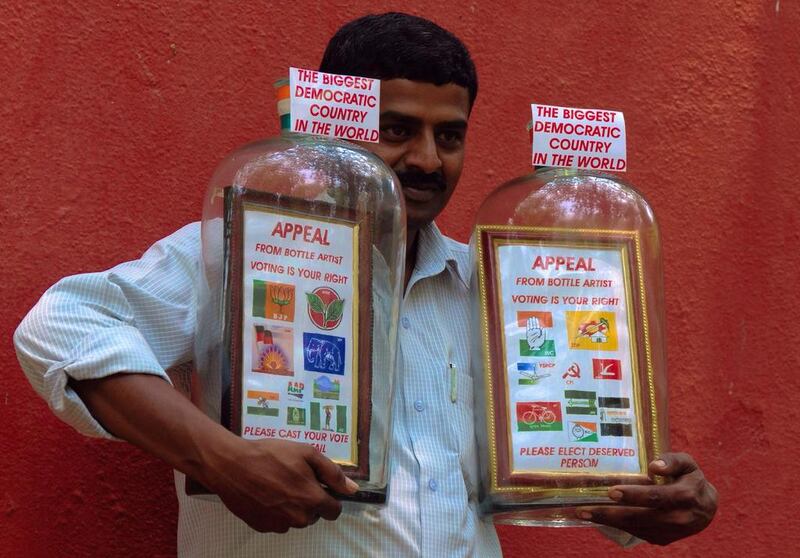 Indian bottle artist Basavaraju Somaraje Gowda, electrician by profession, poses with a framed 8x12 inches photograph which consists of different political party symbols, has he urge people to ‘ Please Cast your Vote’ for the upcoming Lok Sabha election in Bangalore. Jagadeesh NV / EPA 