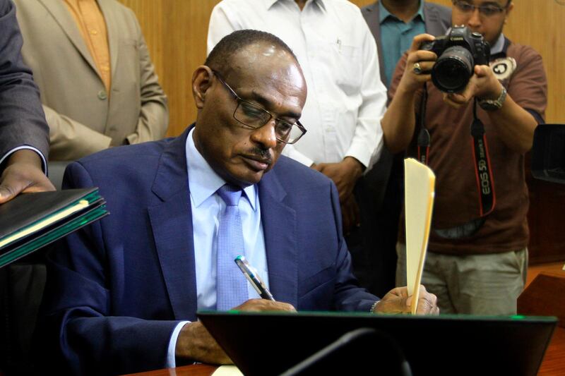 Sudanese Foreign Minister Ahmed al-Dierdiry signs a "preliminary" power-sharing deal between South Sudanese arch-foes, on July 25, 2018, in Khartoum. South Sudanese arch-foes signed a "preliminary" power-sharing deal aimed at ending the civil war, with a Sudanese minister saying it sees rebel leader Riek Machar reinstated as first vice president. / AFP / Ebrahim Hamid
