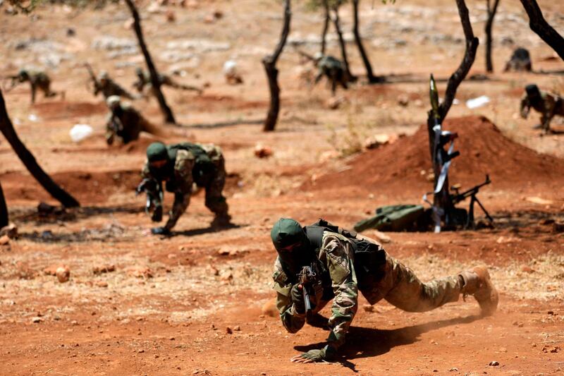 Hayat Tahrir Al Sham fighters stage a mock battle in anticipation of an attack by Syrian regime forces in Idlib province. AFP