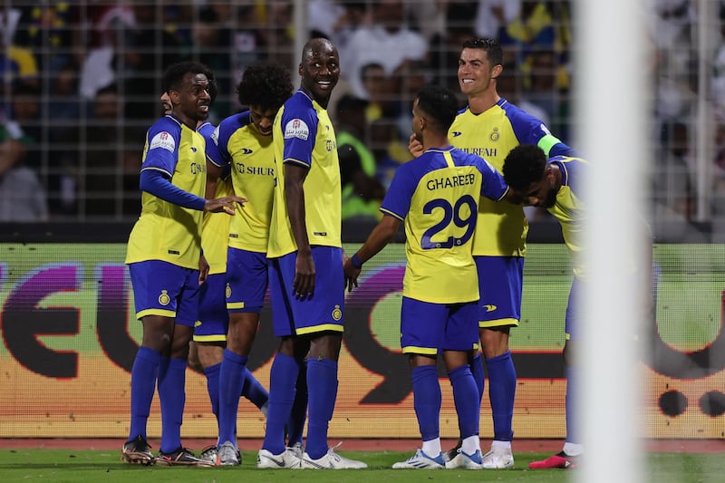 Cristiano Ronaldo celebrates with teammates after scoring his team's third goal. AFP