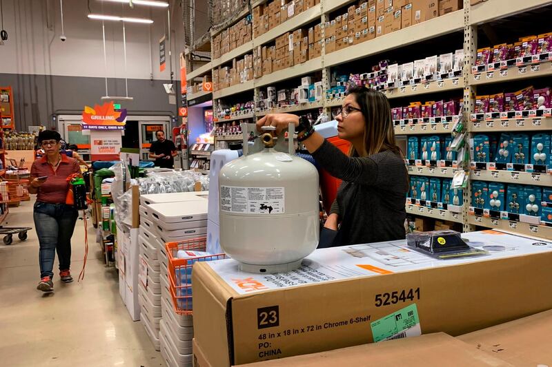 A woman holds the last propane tank at a Home Depot in West Miami. AFP