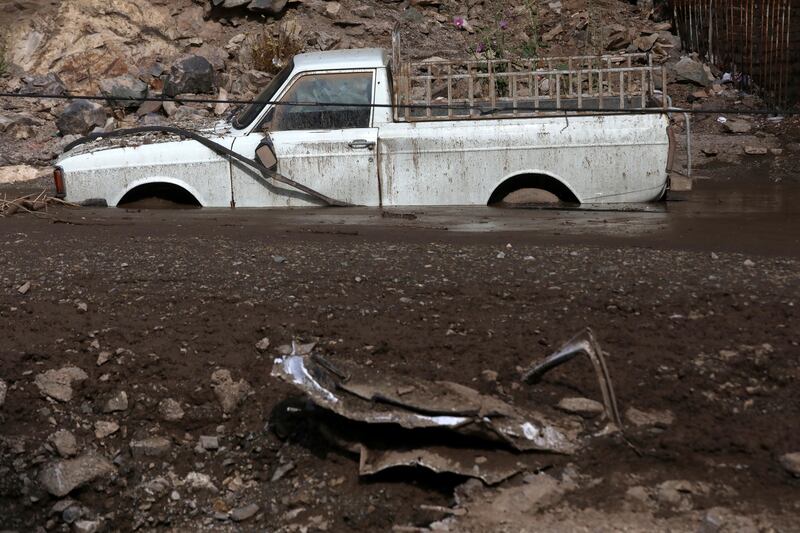 A pick-up truck axle-deep in mud from a landslide in Emamzadeh Davoud. AP Photo