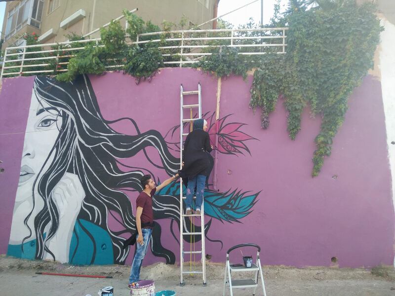 Hind Al Far works on her mural in Amman. Courtesy Baladk Project