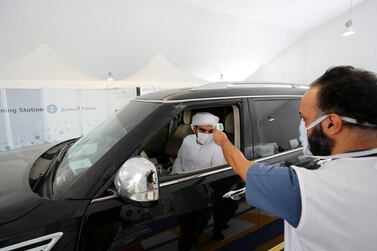 A motorist is screened at the new drive-through centre in Zayed Sports City, Abu Dhabi. Chris Whiteoak / The National