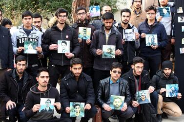 Students hold pictures of the victims of the Ukrainian plane crash in Tehran during a memorial ceremony for passengers in the Iranian capital. EPA