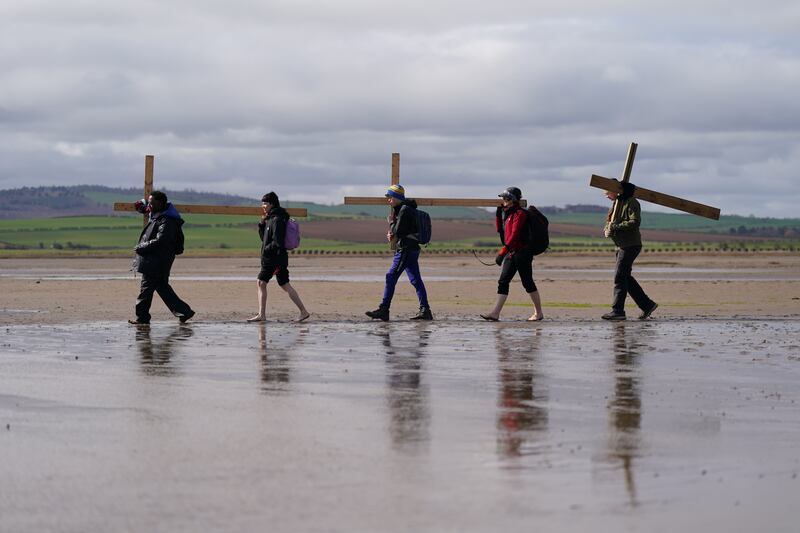 Pilgrims carry crosses over the causeway to Lindisfarne - also known as Holy Island - in north-east England, on the final leg of their Good Friday pilgrimage. Getty