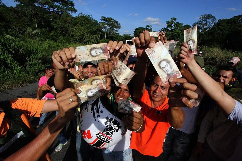 Venezuelans hold up 100-bolivar notes during a protest in San Cristobal in Venezuela’s Tachira state on December 16, 2016. George Castellanos / AFP