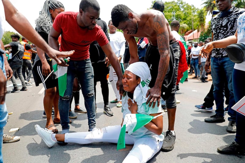 A Nigerian woman weeps as others comfort her during a protest outside their embassy in Pretoria.  AFP